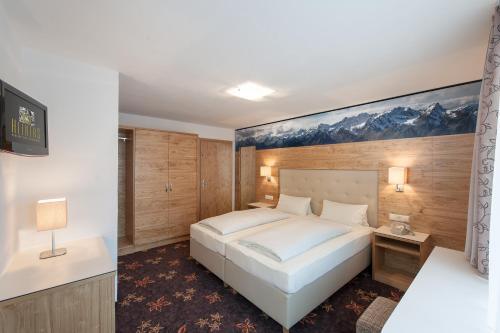 a bedroom with a white bed and a painting on the wall at Heiners in Sölden