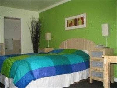 a green bedroom with a rainbow bed and a desk at Sequoia Inn Redwood City in Redwood City