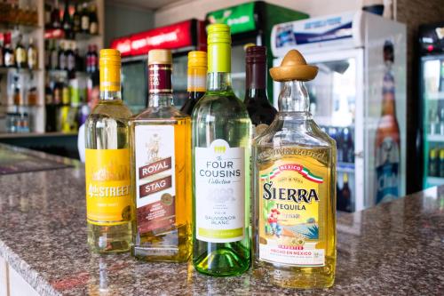 a group of four bottles of wine sitting on a counter at Remmings Hotel Kampala in Kampala