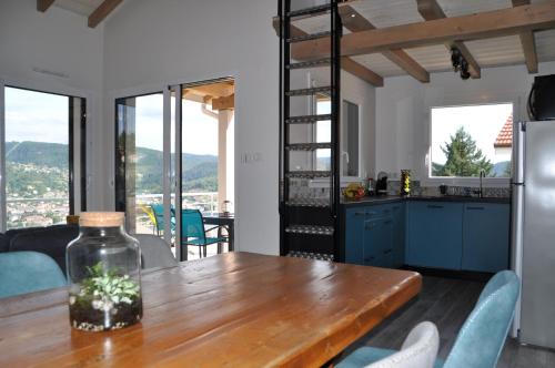 une cuisine avec une table en bois et des armoires bleues dans l'établissement le bleu du lac Sauna et Spa, à Gérardmer