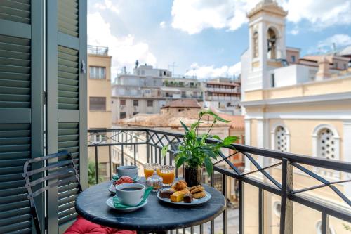 a table with food on a balcony with a view of a city at Noma Hotel in Athens