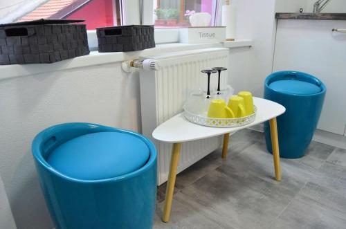 a table with a bowl of bananas on it next to two blue barrels at KAYA STUDIO in Sibiu