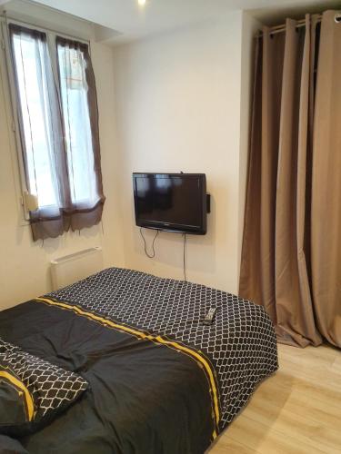 une chambre avec un lit et une télévision à écran plat dans l'établissement Suite Boudet 16, à Reims