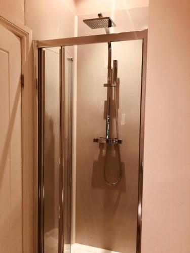a shower in a bathroom with a light on the wall at Maritime Pods in Portsmouth