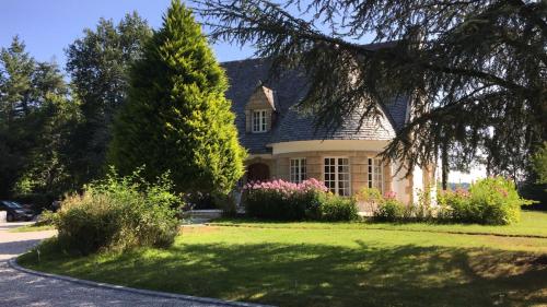 a house with a tree and flowers in the yard at Crown Roads in Le Faouët