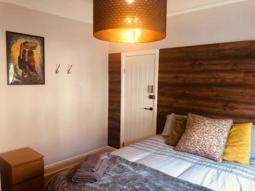 a bedroom with a bed with a wooden headboard at Maritime Pods in Portsmouth