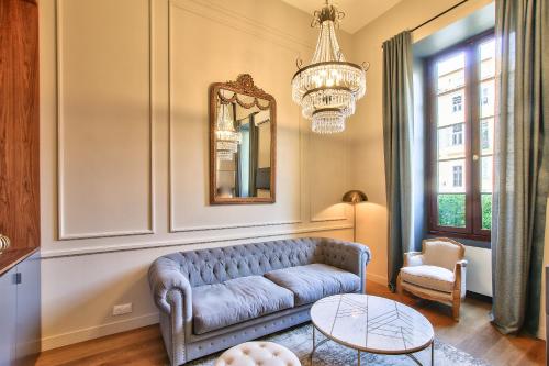 un salon avec un canapé bleu et un lustre dans l'établissement Charming Duplex 2 Suites OLD TOWN, à Nice