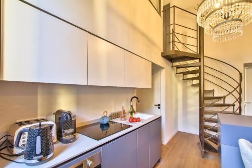 une cuisine avec un escalier en colimaçon en arrière-plan dans l'établissement Charming Duplex 2 Suites OLD TOWN, à Nice