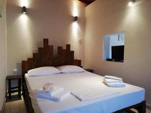 a bedroom with a white bed with two towels on it at Dreamhome -10min from airport- in Artemida