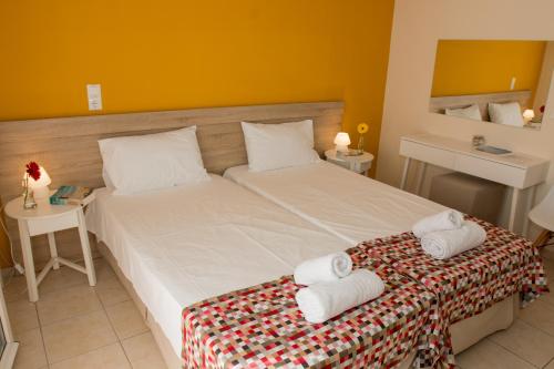 a bedroom with a large bed with towels on it at Sunny Beach Apartments in Rethymno Town