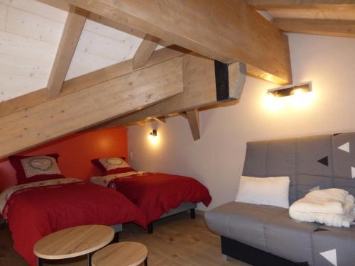 two beds and a couch in a room at les charmes du lac Sauna et Spa in Gérardmer