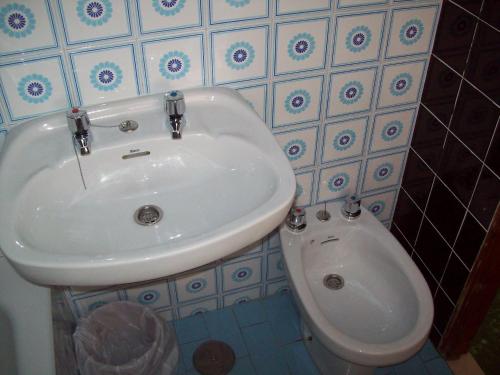 a bathroom with a sink and a toilet at Pensión Los Pinos Gijón in Gijón