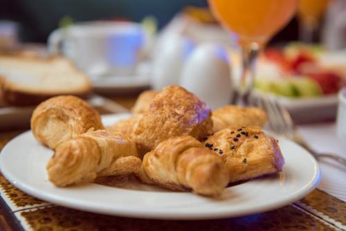 a plate of pastries on a table with a glass of wine at Salma Hotel Cairo in Cairo