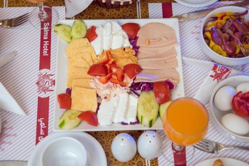 a plate of food with sandwiches and eggs on a table at Salma Hotel Cairo in Cairo