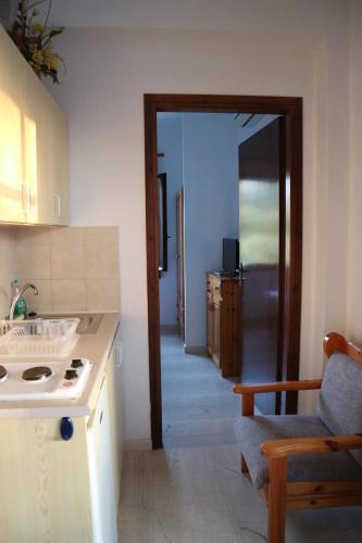 a kitchen with a sink and a door to a room at Oliaria Apartments in Platanias