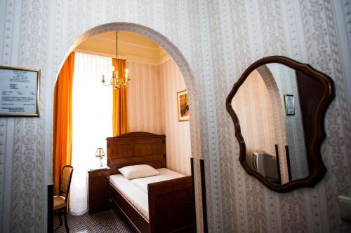a bedroom with a bed and a mirror at Hotel Atlanta in Vienna