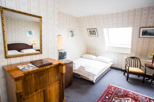 a bedroom with a bed and a mirror and a desk at Hotel Atlanta in Vienna