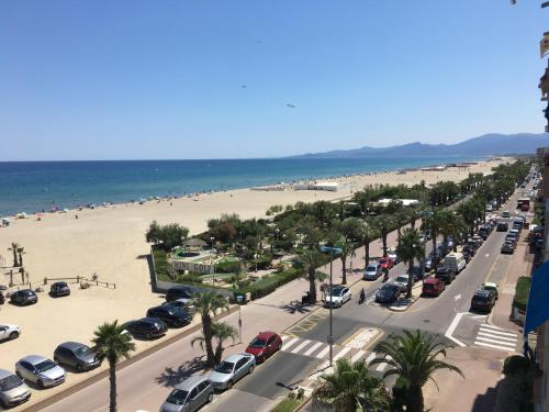 un aparcamiento junto a una playa con coches aparcados en Studio face à la mer, en Canet-en-Roussillon