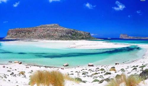 a beach with a small island in the water at Tony Central Luxury Apartment 1 in Chania