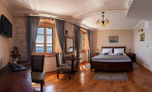 a bedroom with a bed and a table and chairs at Heritage Boutique Hotel Adriatic-Adults only in Orebić