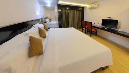 ein großes weißes Bett in einem Hotelzimmer in der Unterkunft Hotel Gokulam Park in Chennai