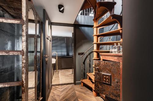 a hallway with an open door and a spiral staircase at Boutique Hotel The Craftsmen in Amsterdam