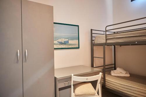 a small room with a desk and bunk beds at CasaMeo in Marsala