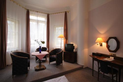 a hotel room with a table and chairs and a television at Dům Bedřicha Smetany in Luhačovice