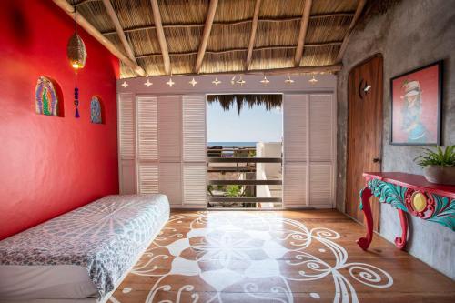 a bedroom with red walls and a bed and a window at Casa Love in Sayulita