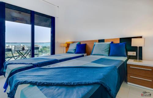 2 camas en un dormitorio con ventana grande en Torrevieja - Punta Prima Sea Senses, en Torrevieja