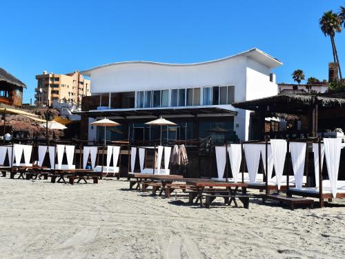a group of chairs and umbrellas on a beach at Castillos Del Mar in Rosarito
