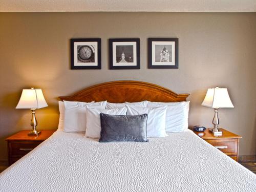 
a bed with a white comforter on top of it at Inn at the Convention Center in Portland
