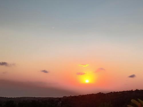 a sunset with the sun in the sky at Rumah Pohon in Nusa Penida