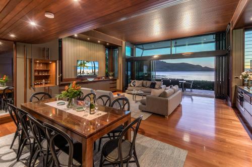 an open living room with a table and chairs at Yacht Club Villas on Hamilton Island by HIHA in Hamilton Island