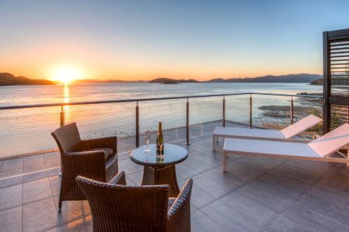 a balcony with a table and chairs and the ocean at Yacht Club Villas on Hamilton Island by HIHA in Hamilton Island