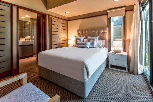 a bedroom with a large bed and a bathroom at Yacht Club Villas on Hamilton Island by HIHA in Hamilton Island