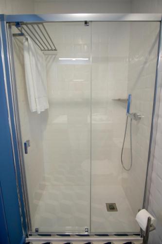 a shower with a glass door in a bathroom at ZIGZAG HOSTEL in Praia da Vitória