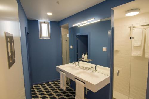 a bathroom with a white sink and a blue wall at ZIGZAG HOSTEL in Praia da Vitória