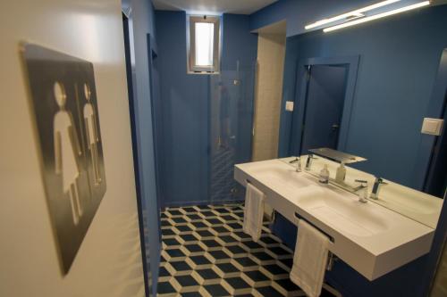 a bathroom with a white sink and a mirror at ZIGZAG HOSTEL in Praia da Vitória