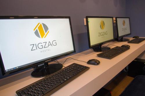 two computer monitors sitting on top of a desk at ZIGZAG HOSTEL in Praia da Vitória
