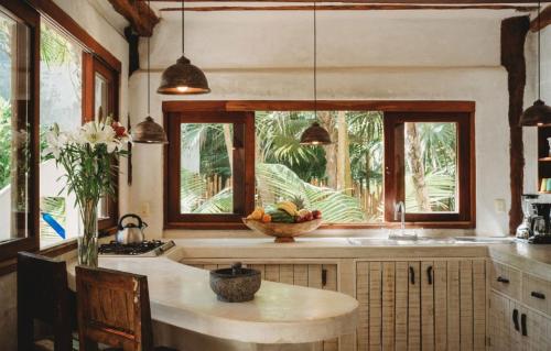 a kitchen with a table with a bowl of fruit on it at Palms house in Tulum