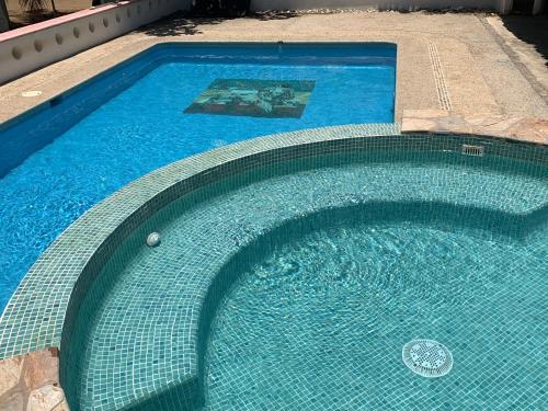 a swimming pool with blue water in a yard at Playa Bruja Zicatela in Puerto Escondido
