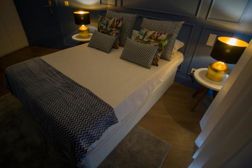 a bed in a room with two tables and two lamps at ZIGZAG HOSTEL in Praia da Vitória