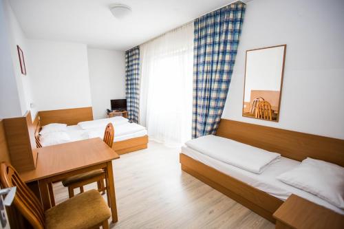 um quarto com 2 camas, uma mesa e uma secretária em Hotel Geblergasse em Viena