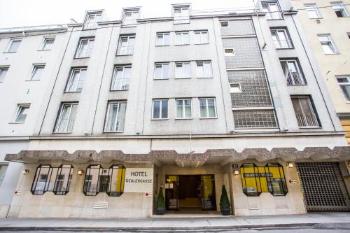 a large white building with yellow doors and windows at Hotel Geblergasse in Vienna