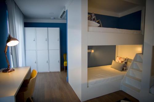 a small room with a bunk bed and a desk at ZIGZAG HOSTEL in Praia da Vitória