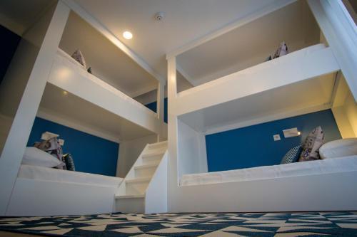 a white bunk bed with white shelves in a room at ZIGZAG HOSTEL in Praia da Vitória
