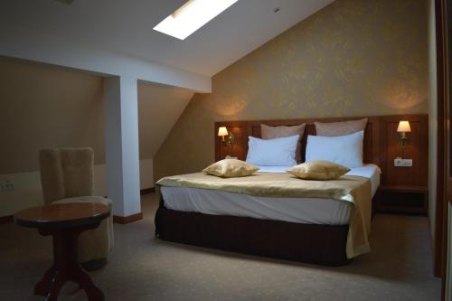 a bedroom with a bed with two pillows on it at Hotel Gott in Braşov