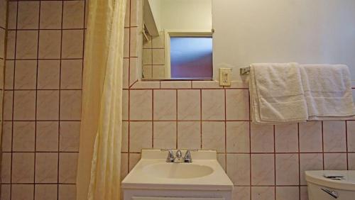 La salle de bains est pourvue d'un lavabo et d'une fenêtre. dans l'établissement Griffith Park Motel, in Los Angeles Hollywood Area, à Glendale