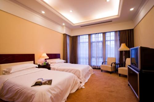 a hotel room with two beds and a flat screen tv at Ramada Plaza Sino-Bay Shanghai in Fengxian